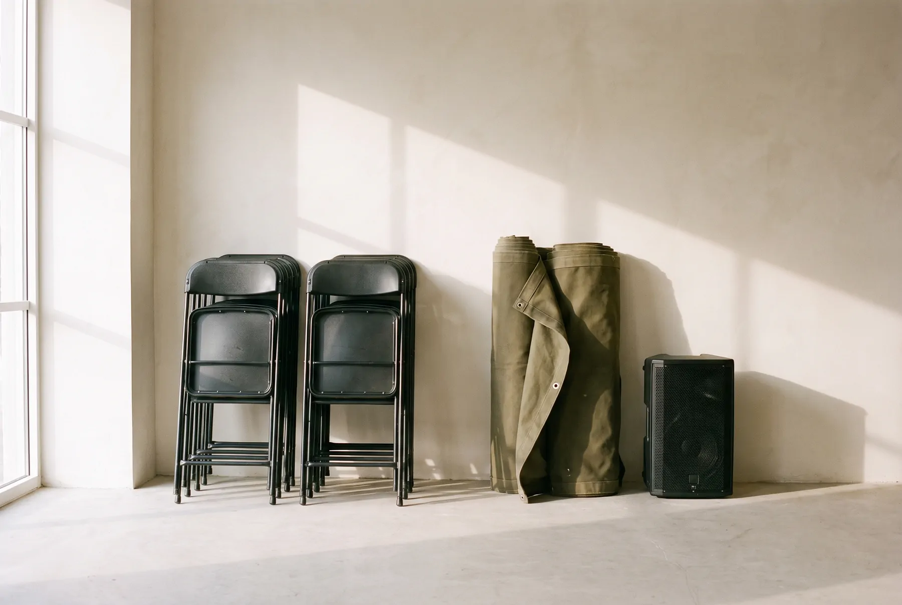 Stacked folding chairs, staging and a speaker in storage