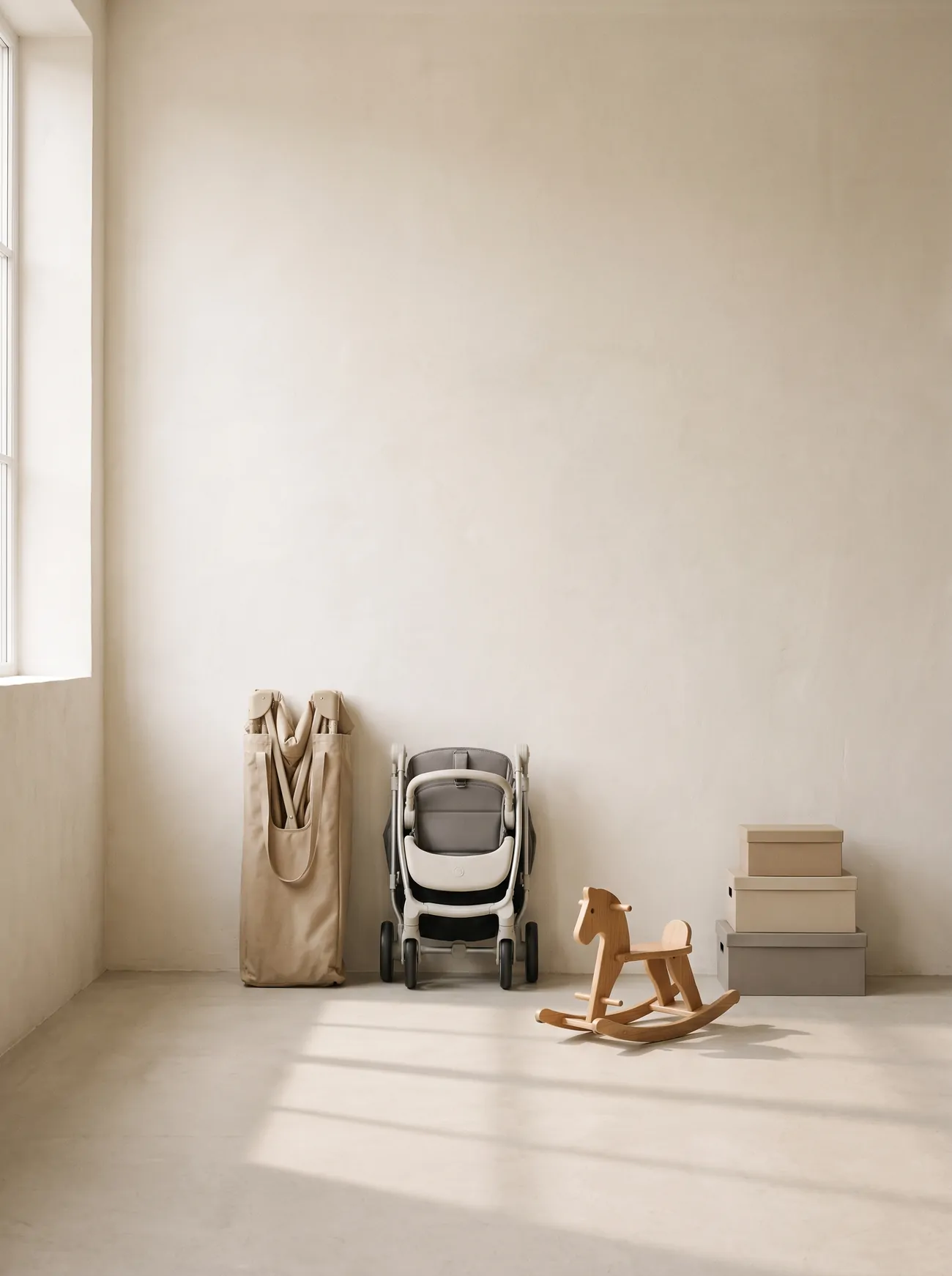 A folded travel cot, a folded pushchair and a wooden rocking toy