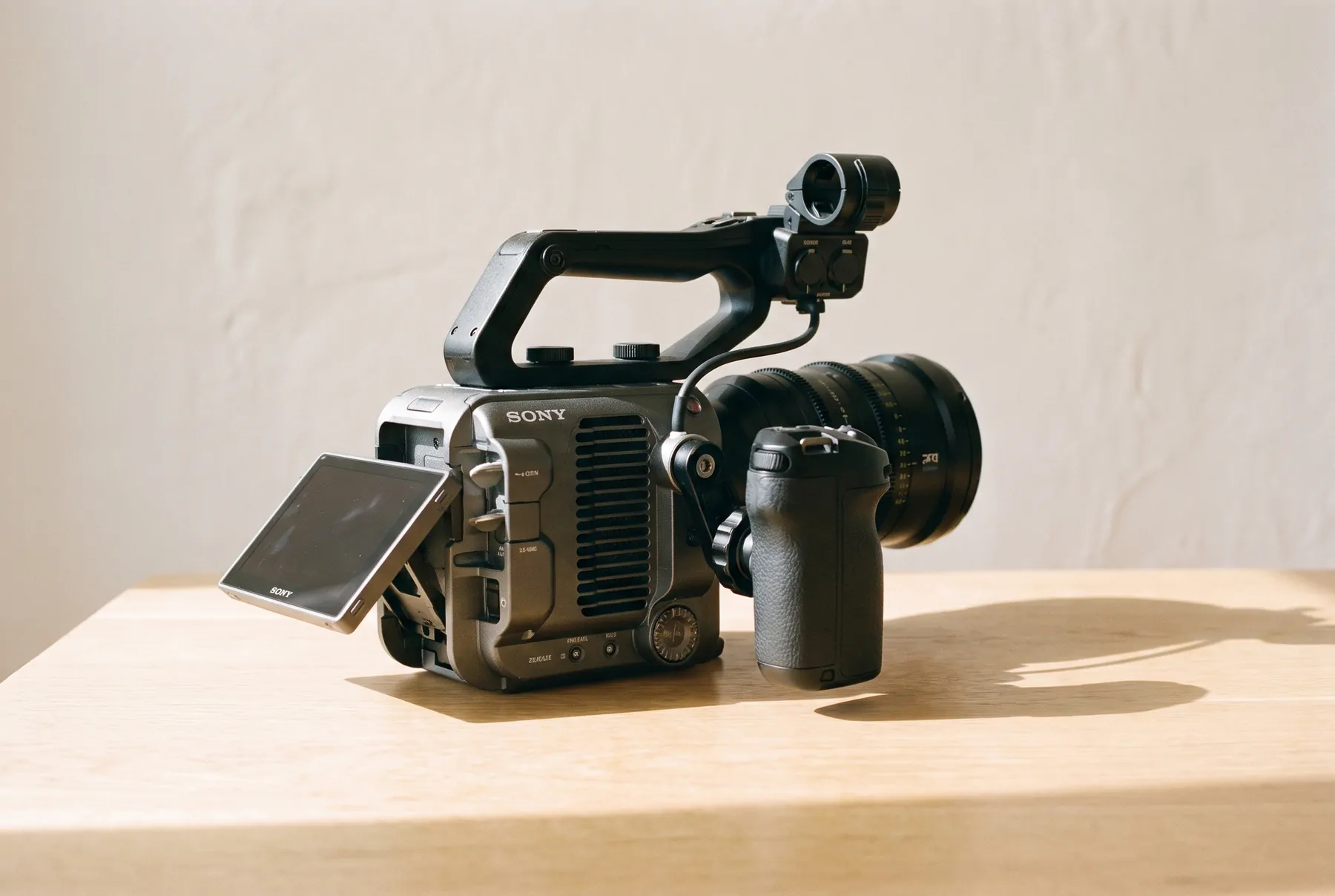 Side view of the camera with the monitor open and the grip attached